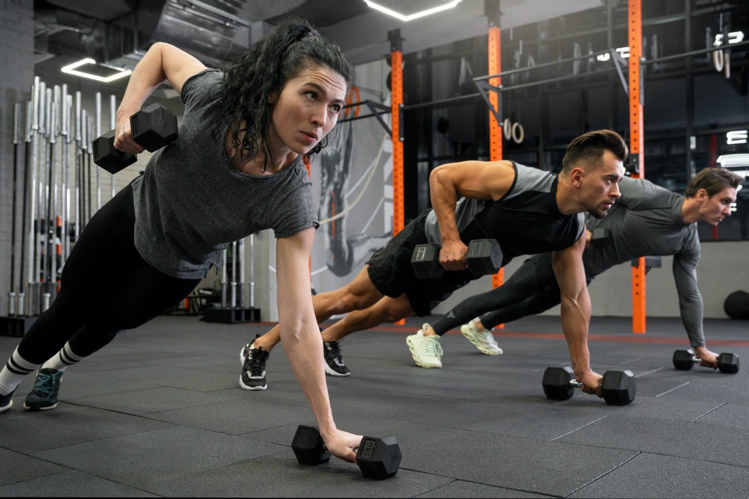 grupo de jovenes entrenando con mancuernas tumbados en el suelo en Fitness en Querétaro