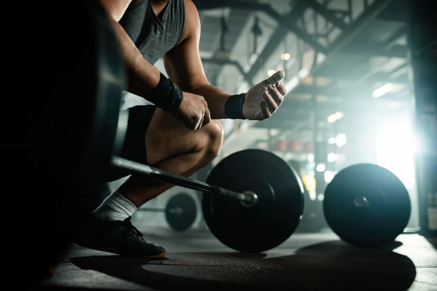 hombre joven levantando barra de persas en grupo de jovenes entrenando con mancuernas tumbados en el suelo en Fitness en Querétaro