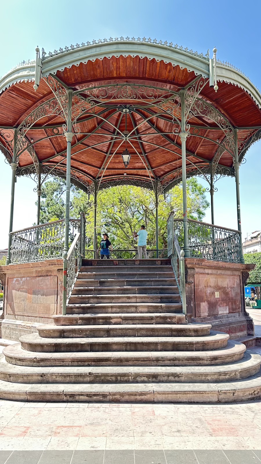 Jardín Zenea en el Centro Histórico de Querétaro, rodeado de árboles, kiosco y arquitectura colonial.