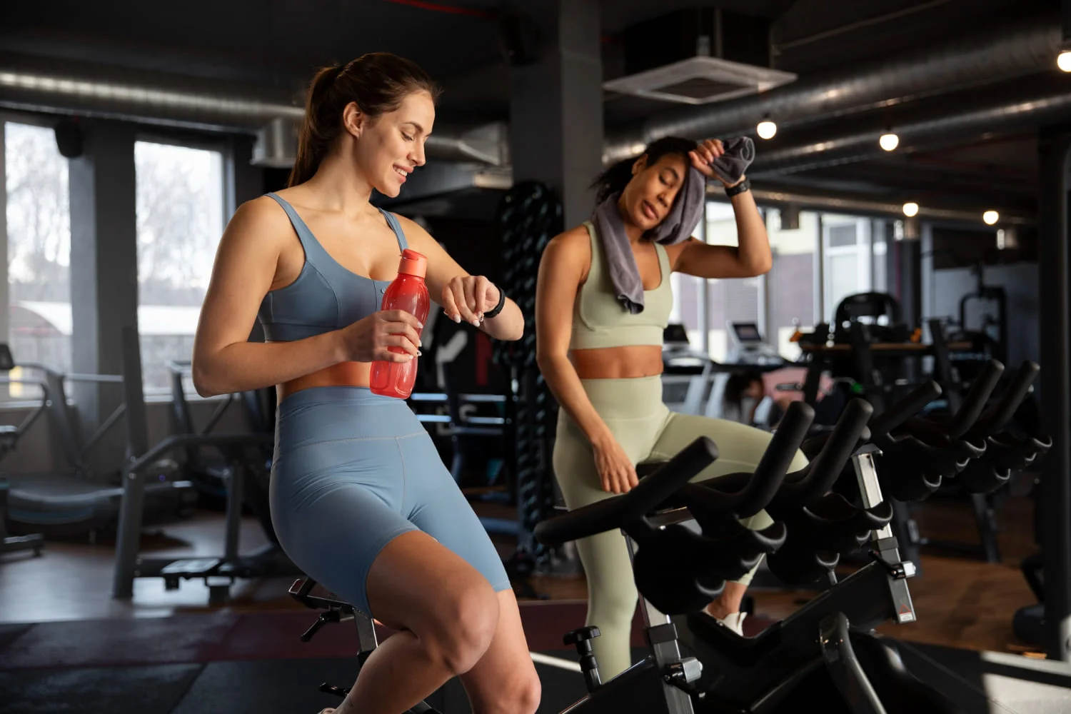 Dos amigas disfrutando de una sesión de spinning en un gimnasio de fitness en Querétaro