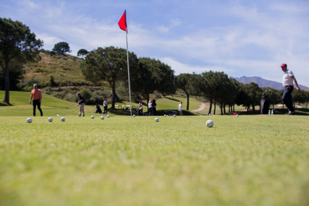 Un grupo de golfistas ejecutando sus swings con precisión en el tee del Club de Golf Juriquilla. logo oficial de Club de Golf Juriquilla vista panorámica de hoyo 7