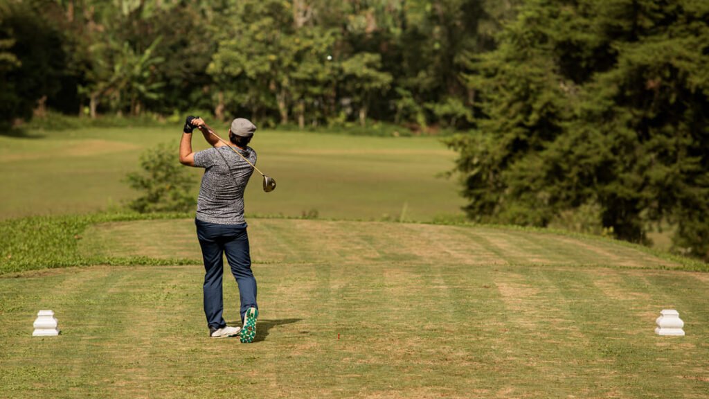 Momentos de golf inolvidables te esperan en el Club de Golf Juriquilla Un golfista levantando su palo con triunfo después de un tiro exitoso en el Club de Golf Juriquilla.