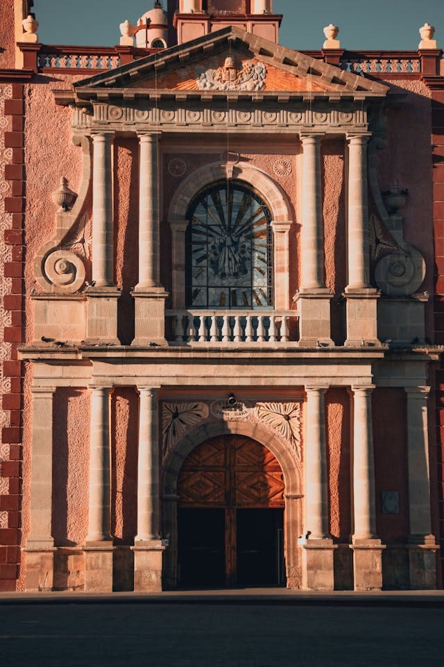 vista frente de Parroquia de Santa María de la Asunción tequis Vista frontal de la Parroquia de Santa María de la Asunción en Tequisquiapan, Querétaro, con su imponente arquitectura neoclásica iluminada por la luz del día.