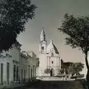 Vista histórica de la calle Zaragoza en Cadereyta de Montes, Querétaro, con el Templo de Nuestra Señora del Refugio al fondo. Fotografía en blanco y negro.