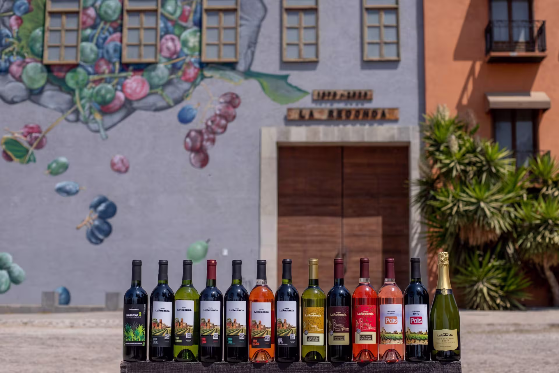 Botellas de vino frente al mural artístico en Viñedos La Redonda.