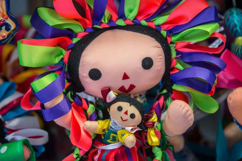 La madre de la muñeca Lele sostiene con orgullo a la pequeña artesanía otomí entre sus brazos en Amealco