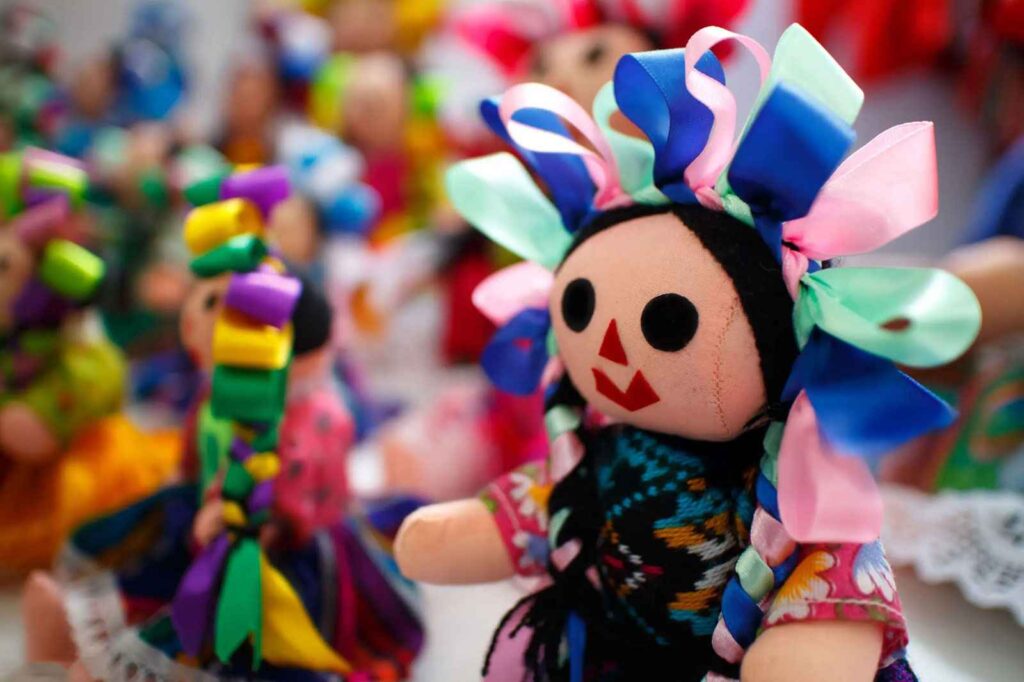 Primer plano de muñeca Lele artesanal otomí con listones de colores