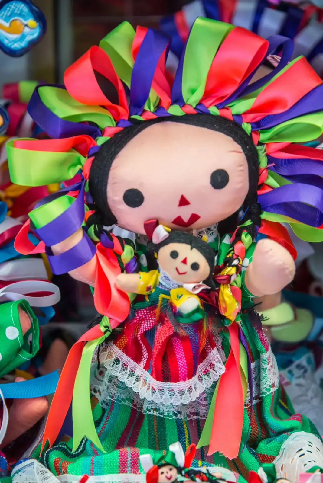 Muñeca Lele con vestimenta tradicional sosteniendo a su bebé Lele – representación otomí del cuidado y herencia cultural en Amealco