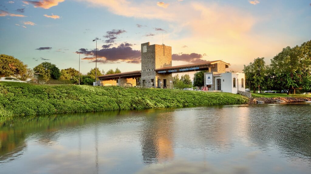 El Campanario, Querétaro – Acceso Monumental con Lago y Cielo Dorado Acceso monumental a El Campanario, Querétaro con lago y atardecer una