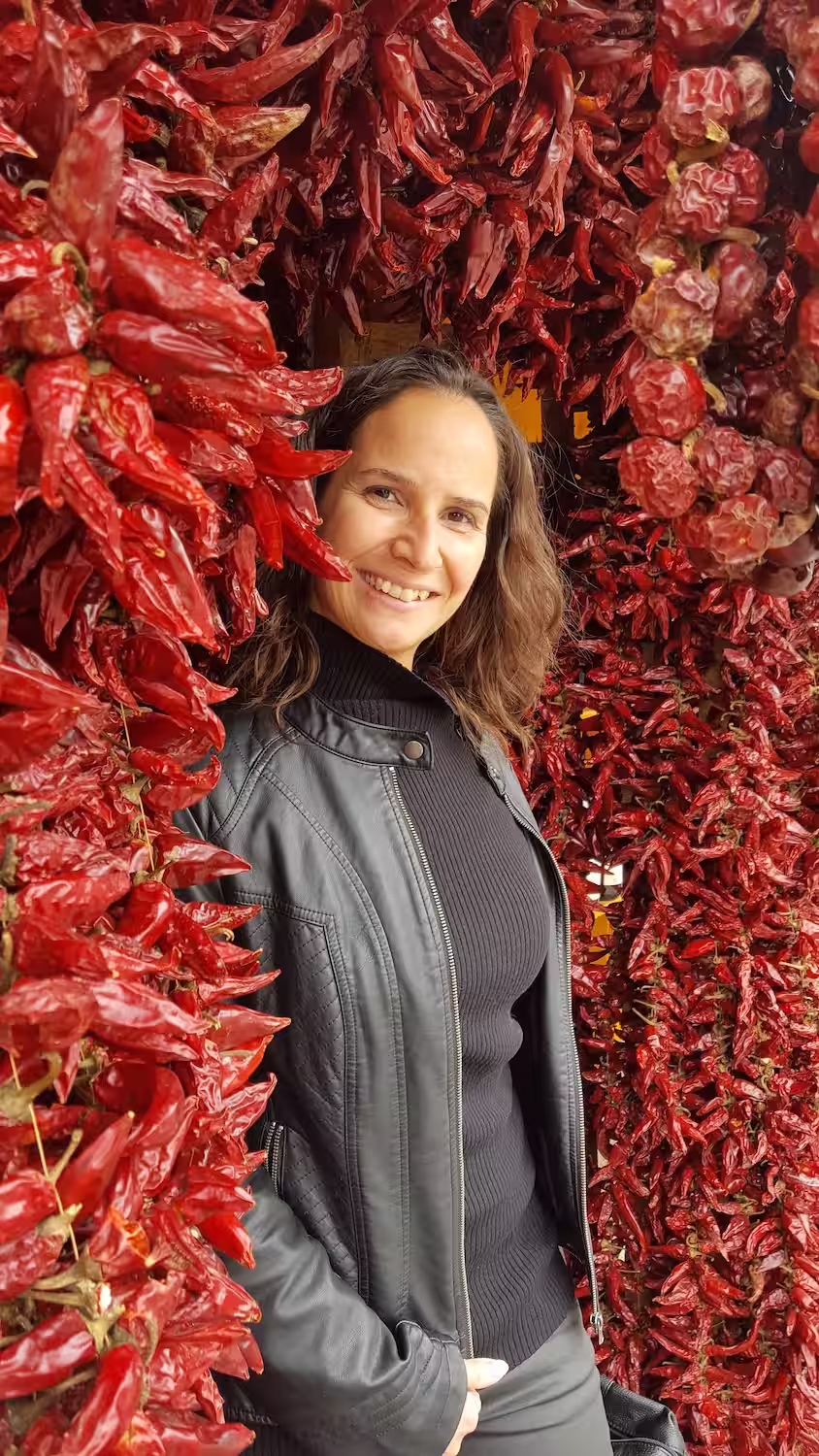 Retrato de mujer mexicana en un mercado de Querétaro rodeada de chiles y pimientos