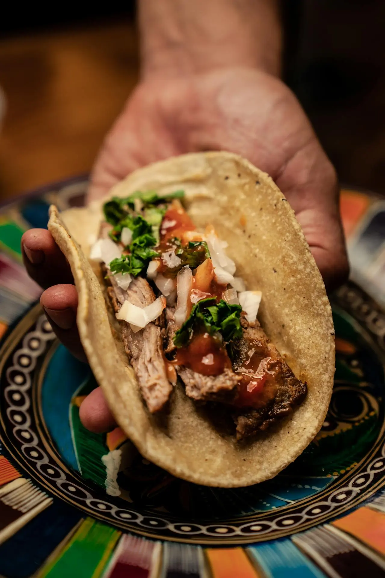 Taco de carnitas servido por un taquero en Querétaro – tradición gastronómica mexicana capturada desde la raíz