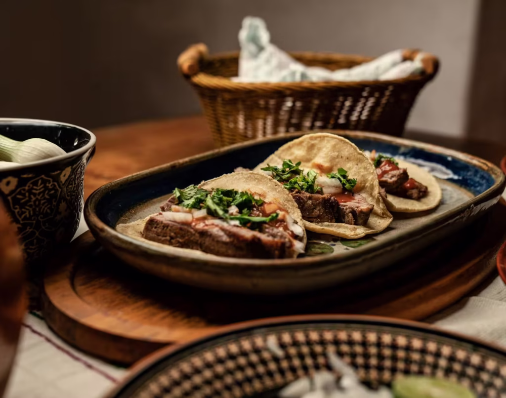 porcion de tacos de carnitas servidos en plato de ceramica de gress