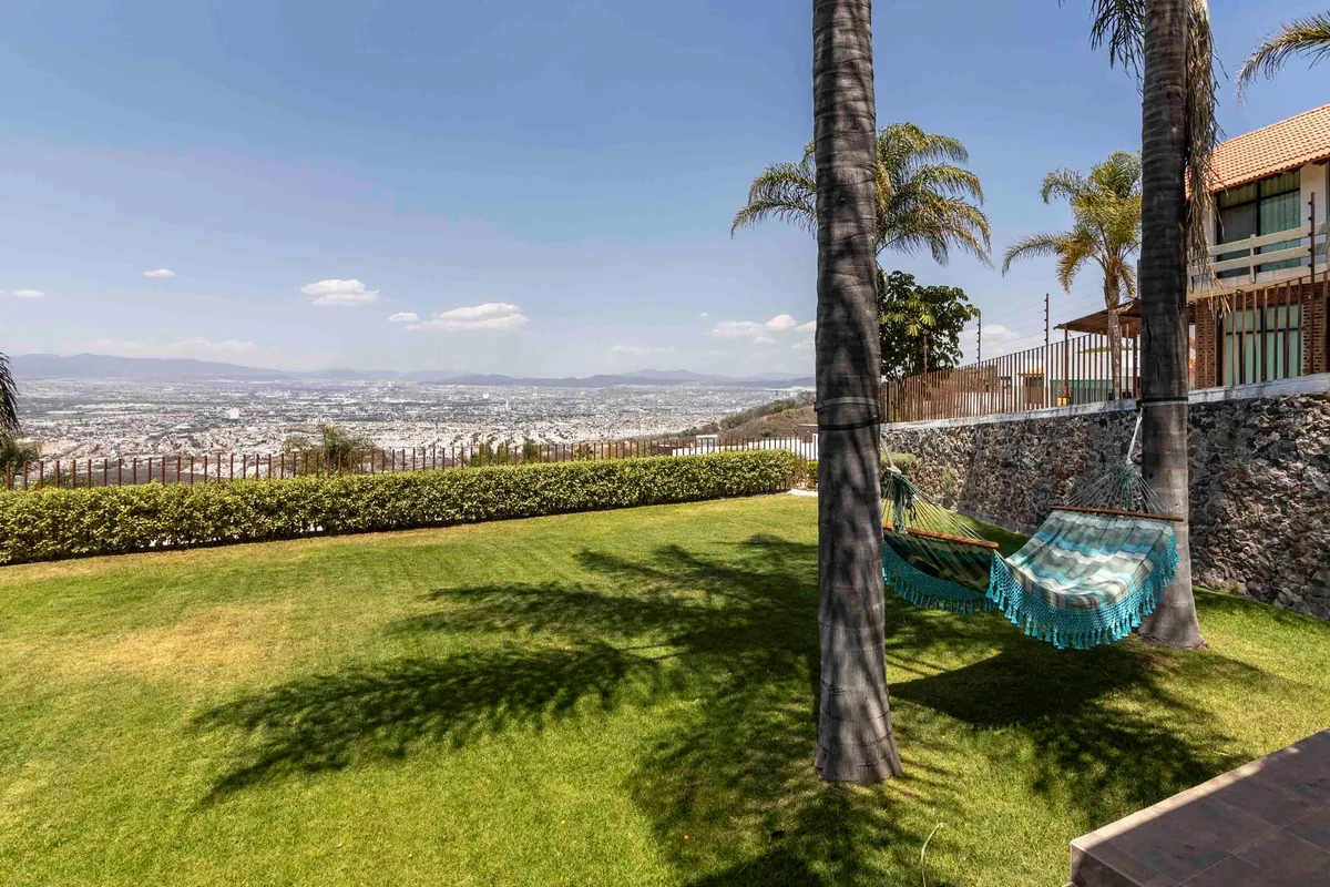 Jardín con palmeras, hamacas y vista panorámica de la casa en Vista Real