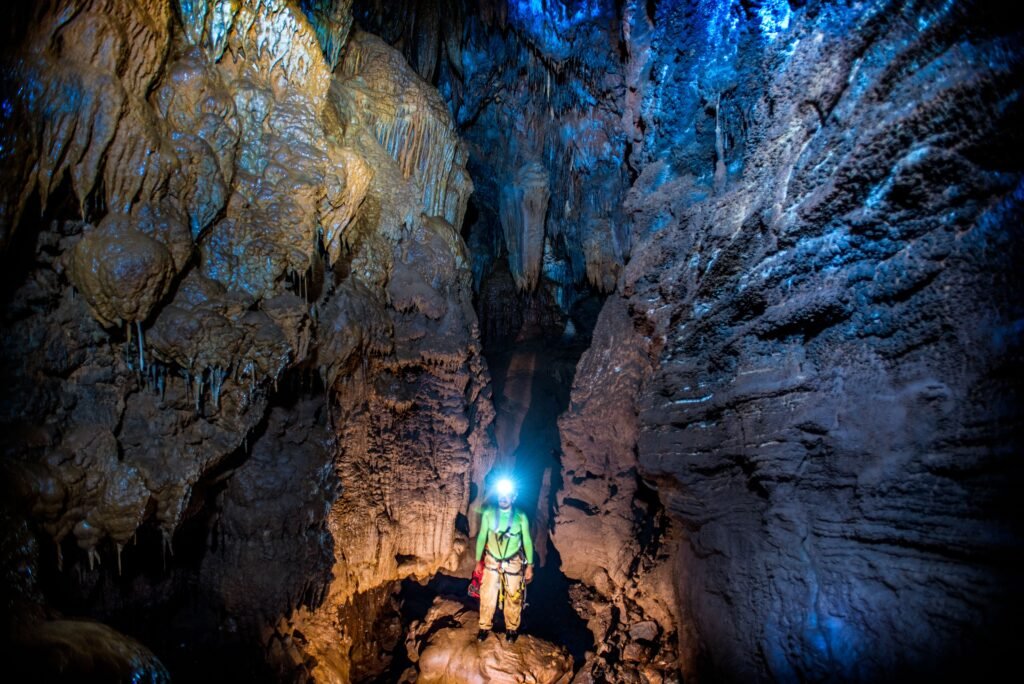 Imagen ilustrativa de una persona con luz frontal explorando una cueva